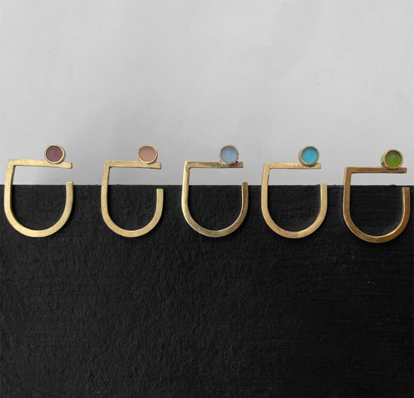 Handmade gold rings with frosted glass accents in vibrant colors,Bauhaus inspired, showcasing a minimalist and modern design.