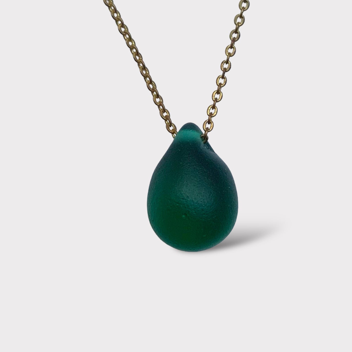 Emerald green matte teardrop pendant necklace with a frosted glass finish, handcrafted and strung on a stainless steel chain. A timeless design inspired by lush summer greenery.