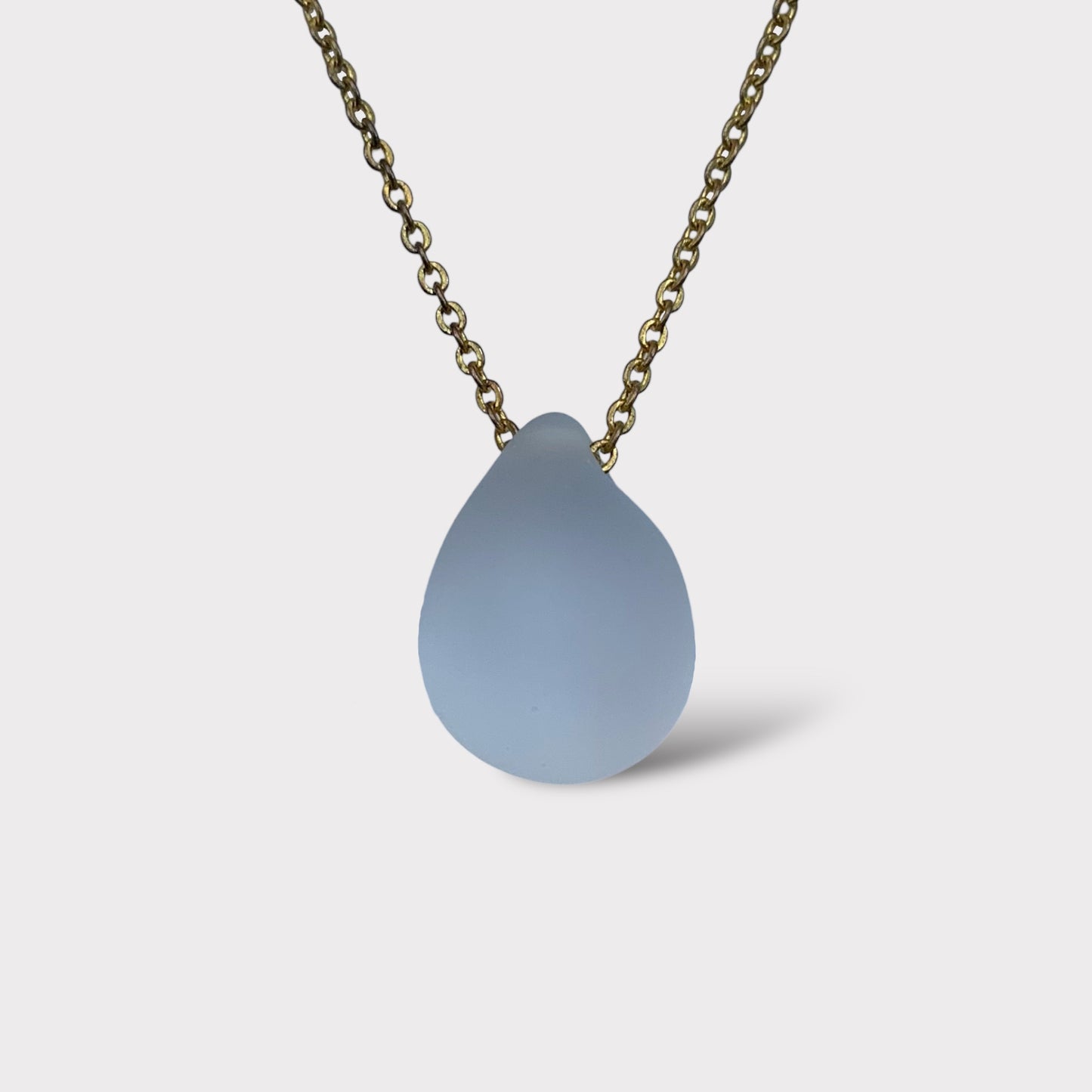 Frosted white matte teardrop glass pendant necklace, suspended on a minimalist stainless steel chain. A clean and versatile design that pairs effortlessly with any outfit.
