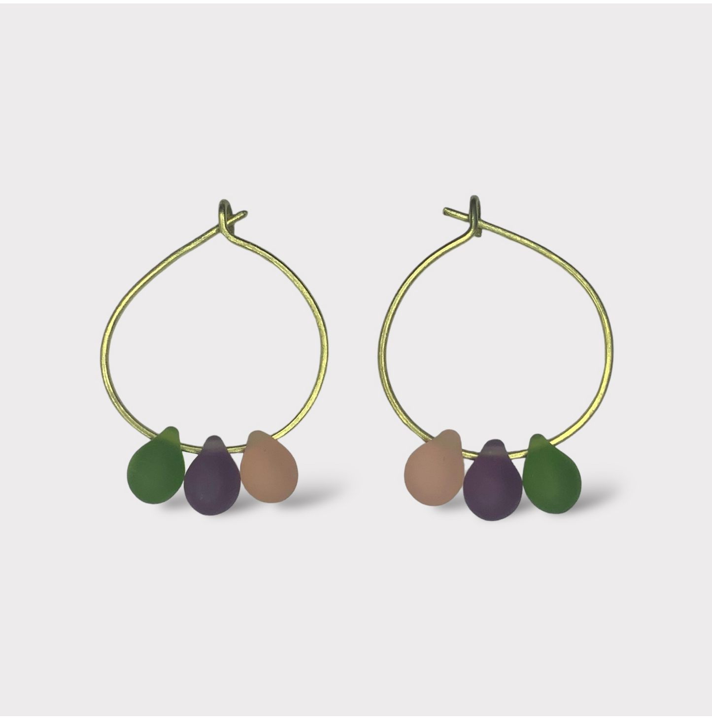 Minimalist gold hoop earrings featuring pastel seaglass drops in lavender, mint green, and sunny yellow. Inspired by the sweet and colorful world of French macarons.