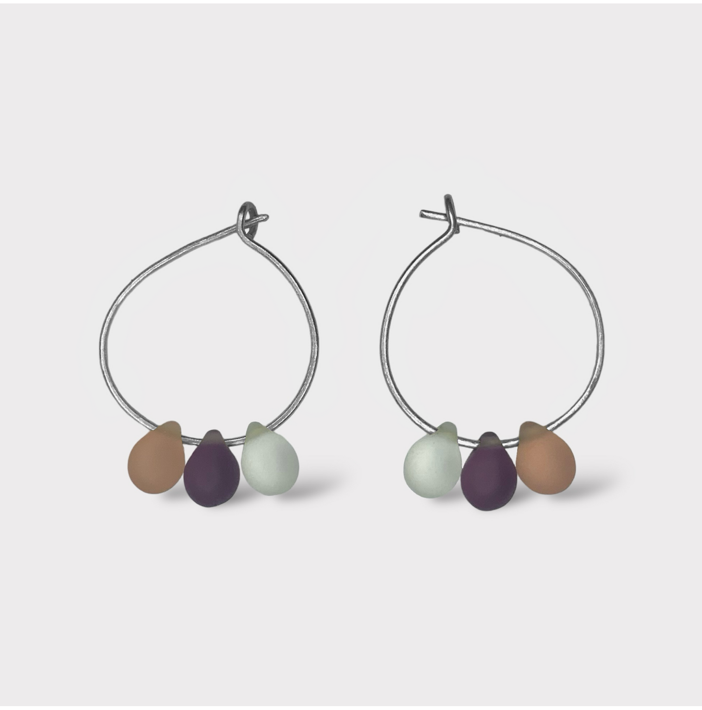 Delicate silver hoop earrings with pastel seaglass charms in peach, cream, and lavender. A soft and feminine design inspired by the sweet taste of peaches and cream.