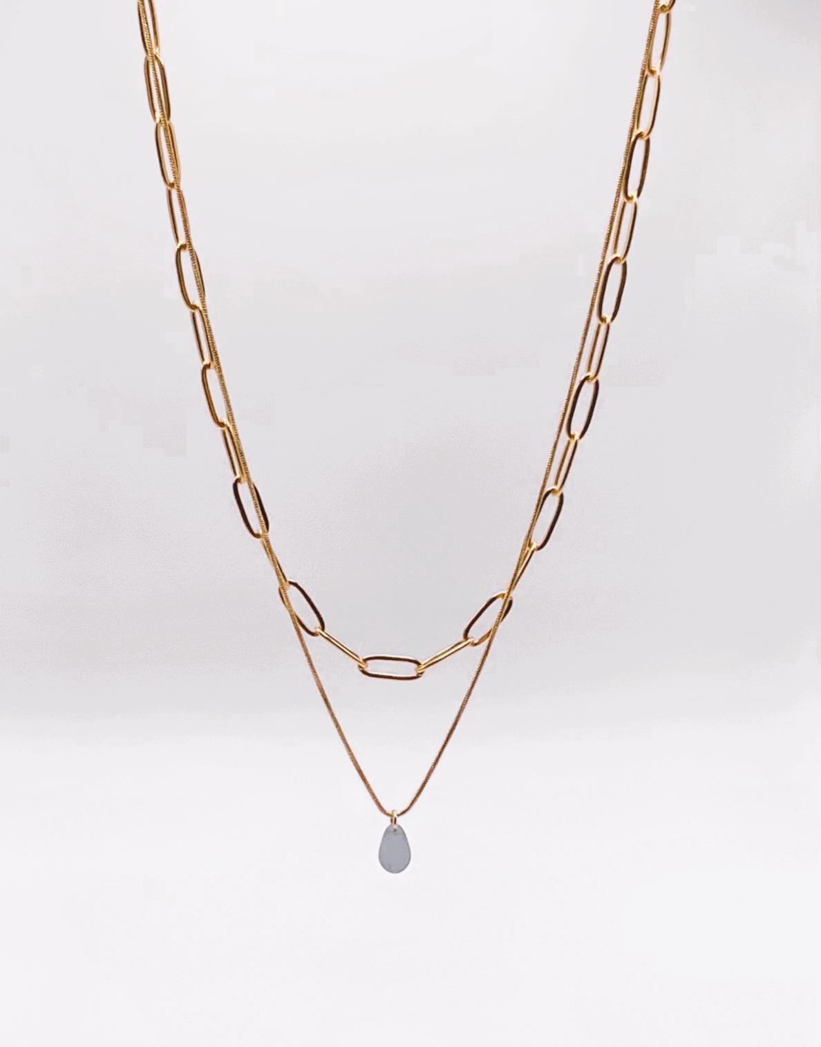 Layered gold cable chain and snake chain necklace with a blue sea glass pendant, blending modern style with timeless charm. Greek modern jewelry by jewelry by Meow.