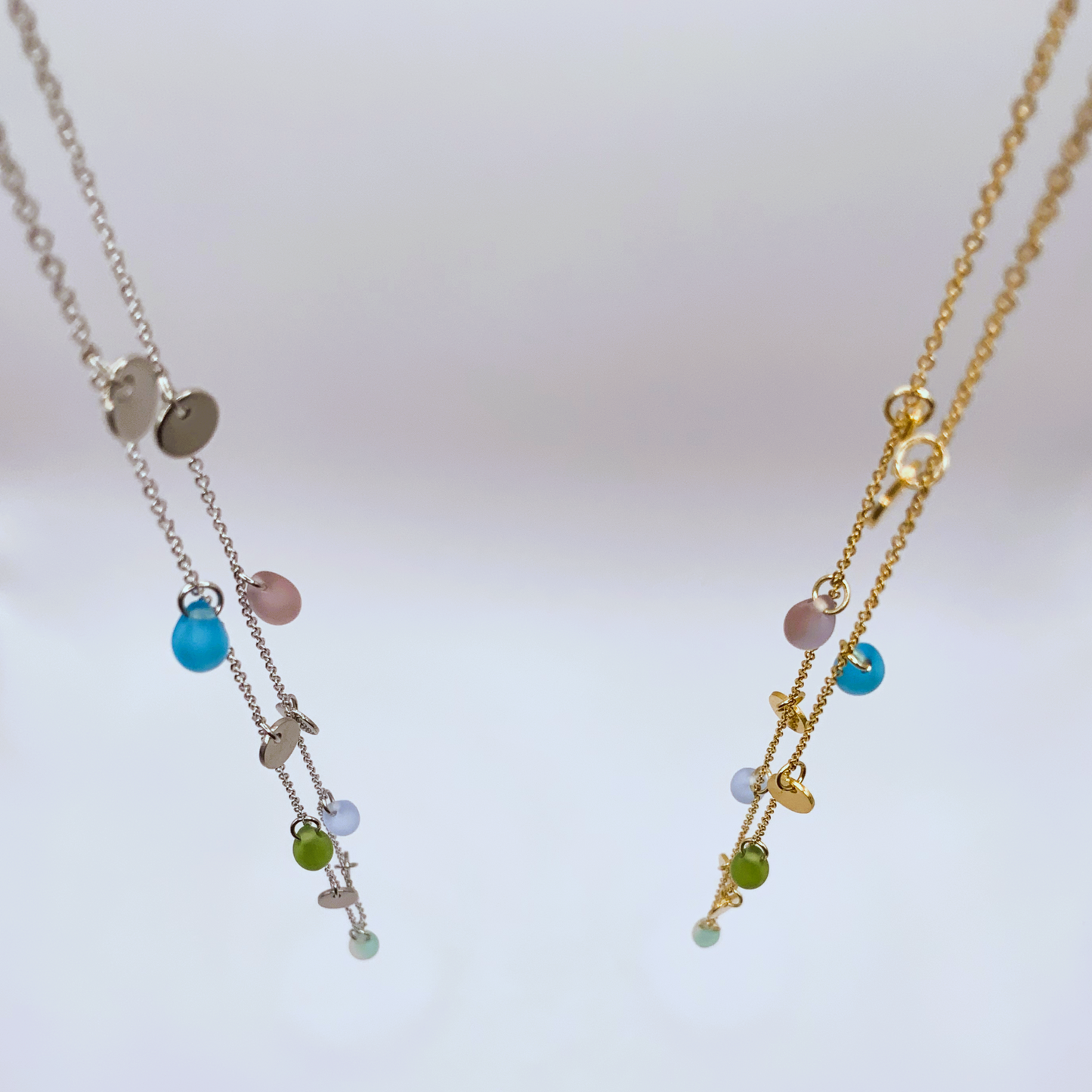 Gold and silver chain necklaces with frosted glass beads in vibrant hues and coin charms, handcrafted in Greece. A unique and modern design for women who embrace individuality.