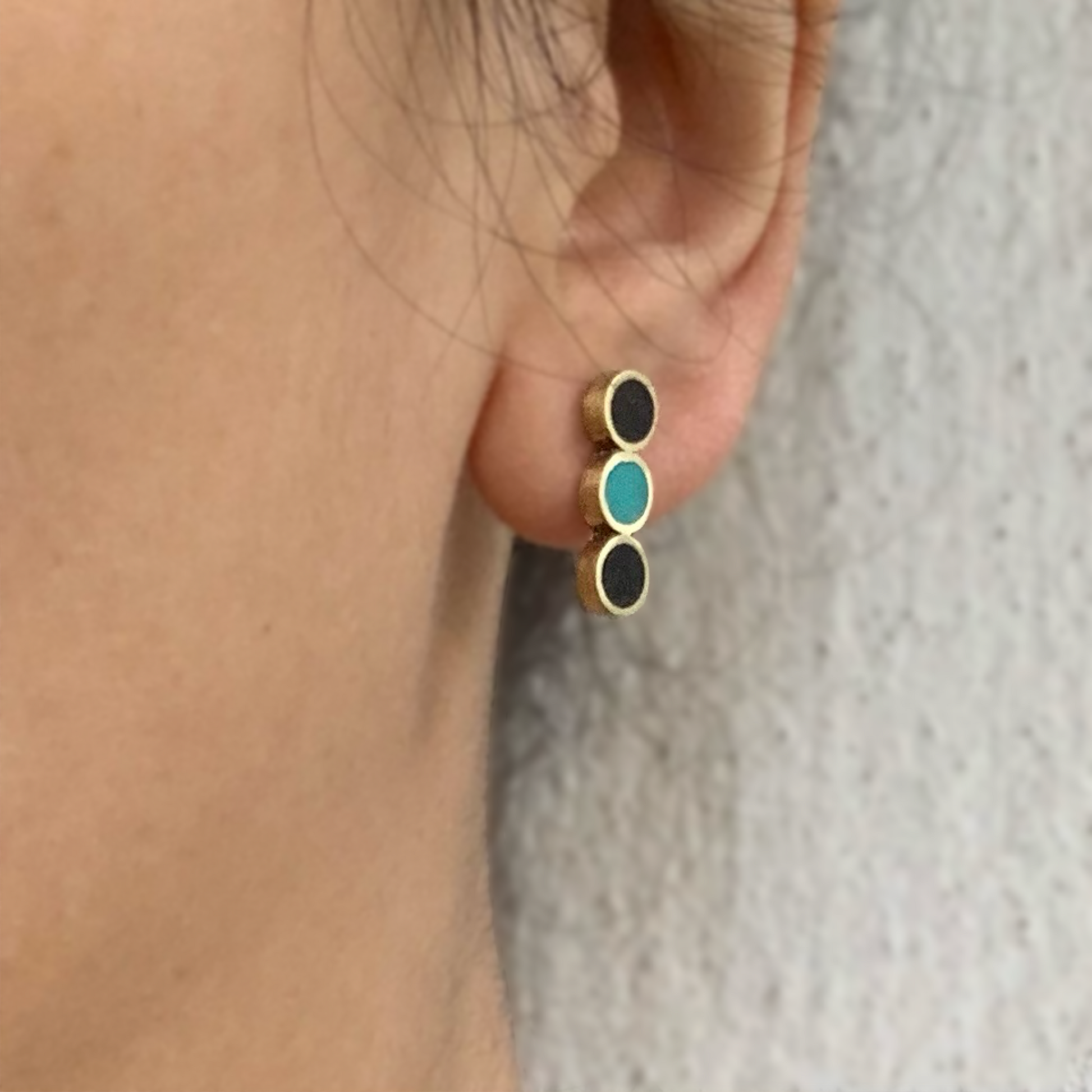 closeup-of-ear-with-handmade-artisan-greek-minimalist-stud-earrings-with-three-circle-shapes-with-black-and-turqoise-poymer-clay-inlay-jewelry-by-meow-dusk-and-dawn-collection-focal-studs