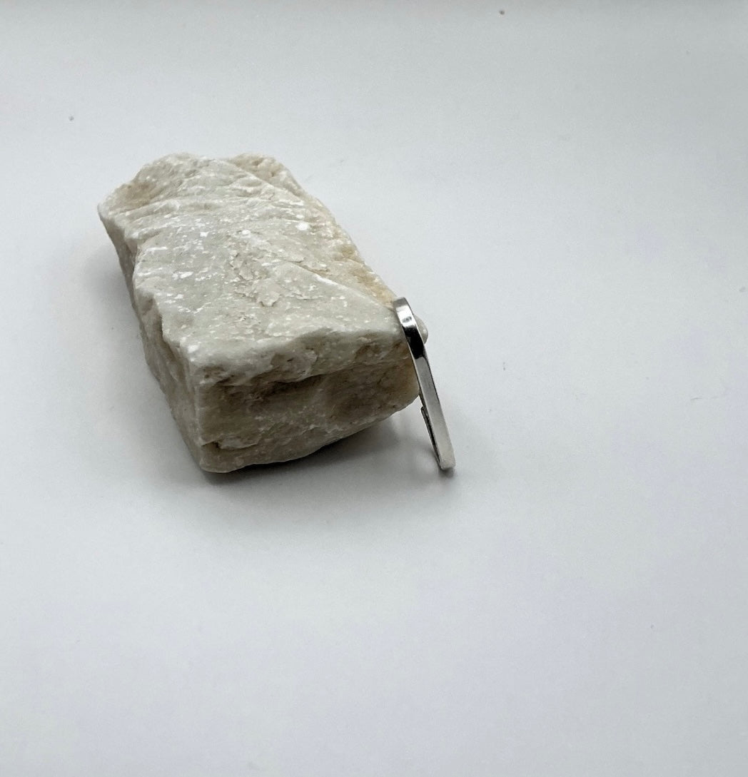 Side view of the Minimalist Curve Sterling Silver Ear Hook shown on a light stone background.