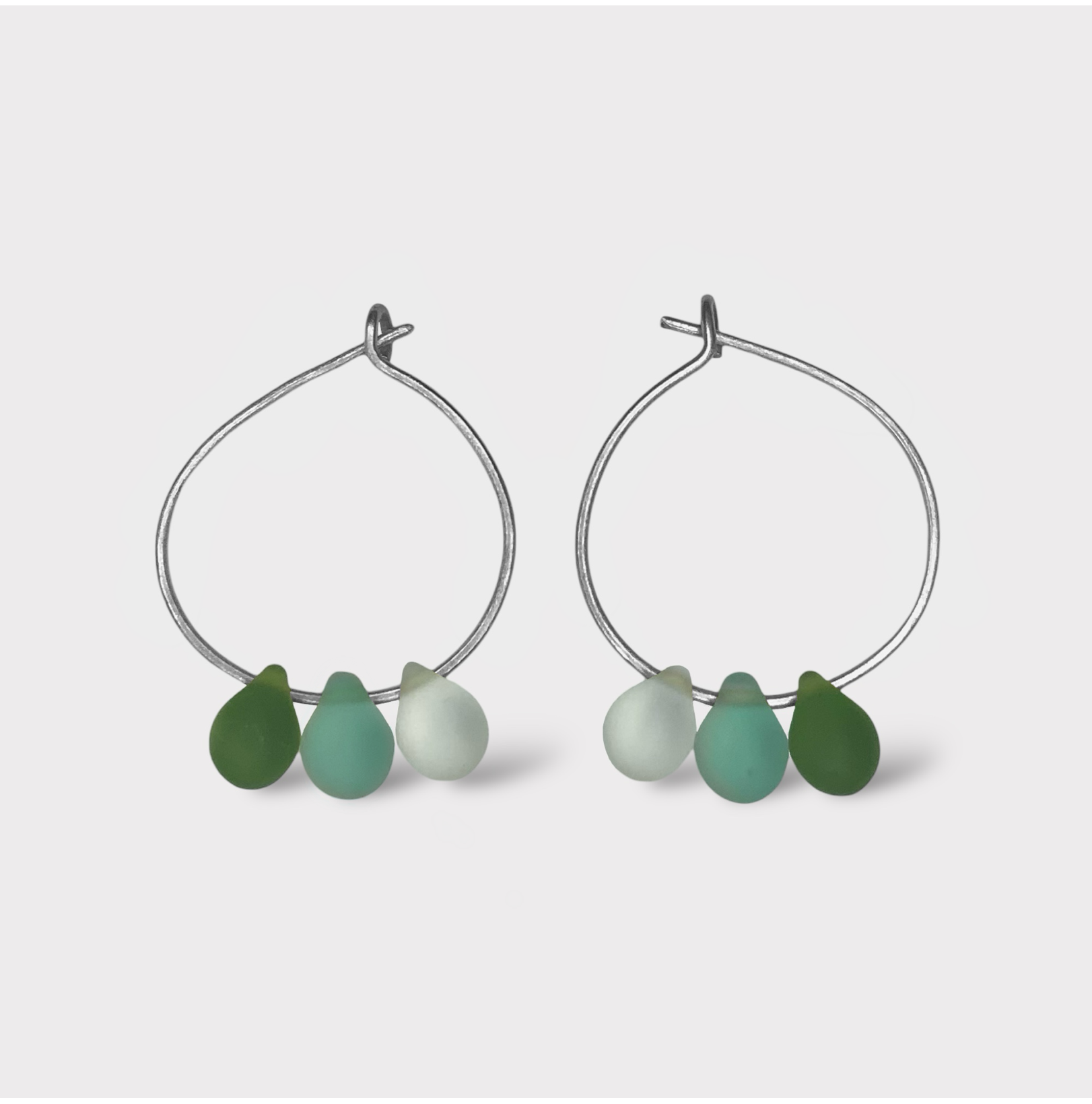 Refreshing silver hoop earrings with seaglass charms in mint green and seafoam hues. A clean and modern design inspired by the cool taste of mint and matcha.