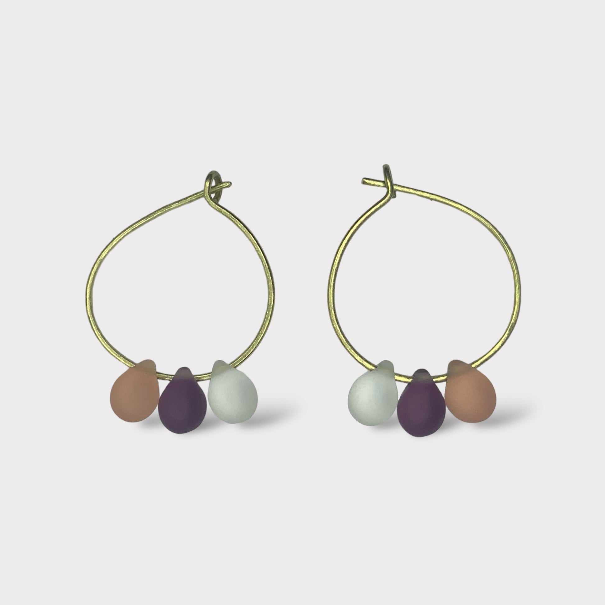 Elegant gold hoop earrings with pastel seaglass charms in peach, cream, and lavender tones. A soft and sophisticated design inspired by the sweetness of peaches and cream.
