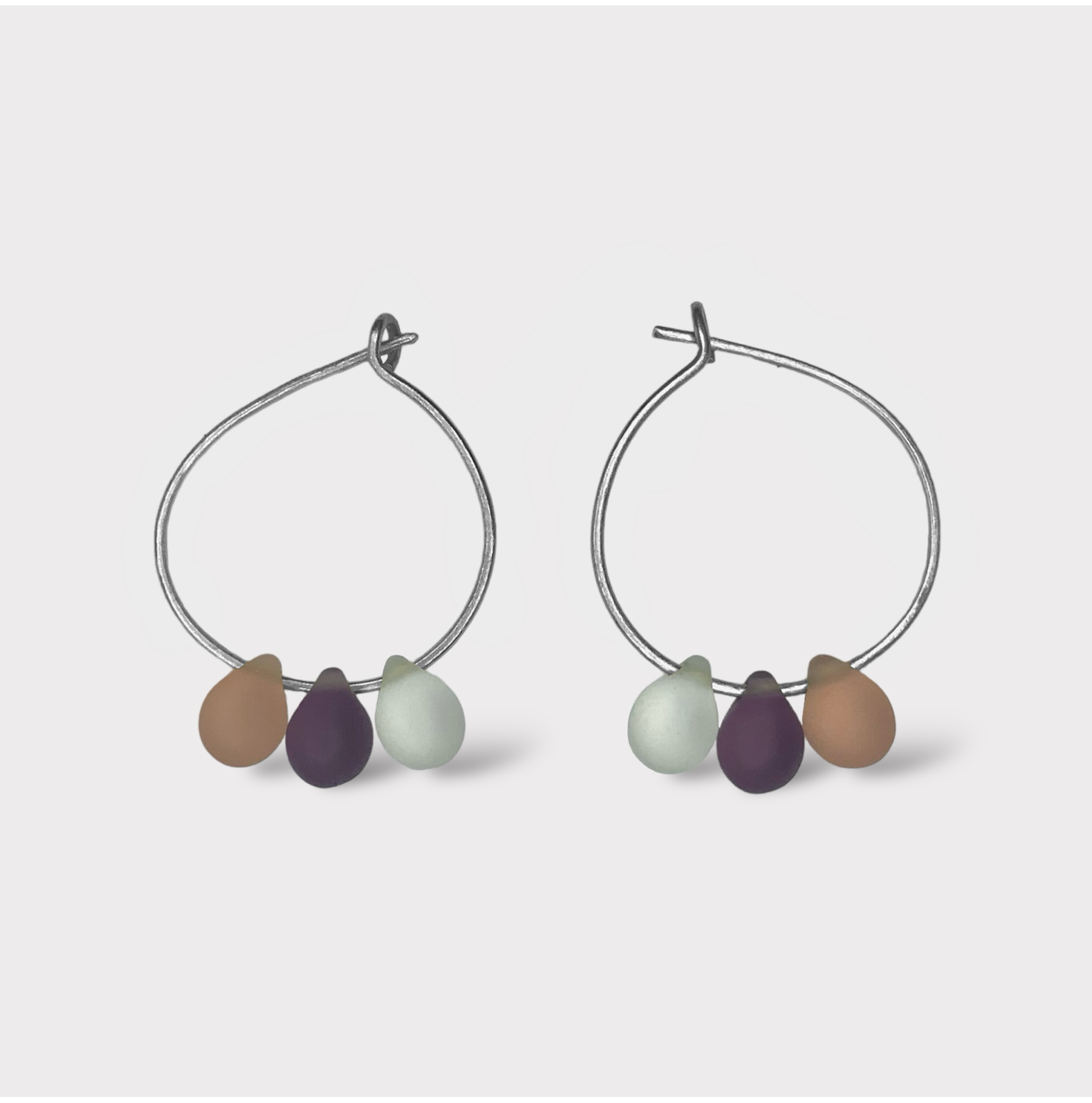 Delicate silver hoop earrings with pastel seaglass charms in peach, cream, and lavender. A soft and feminine design inspired by the sweet taste of peaches and cream.