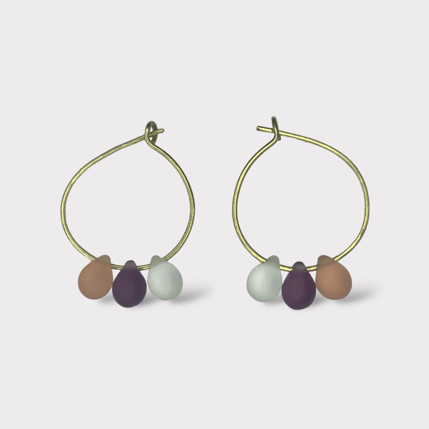 gold-minimalist-small-hoop-earrings-with-matte-frosted-glass-teardrop-beads-in-pastel-colors-white-background-product-photo-jewelry-by-meow-iris-collection-arsinoe-peaches-cream-earrings-greek-handmade-summer-jewelry