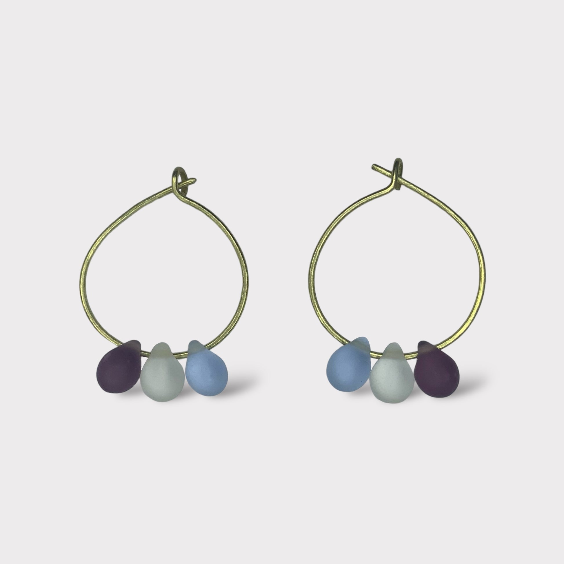 gold-minimalist-small-hoop-earrings-with-matte-frosted-glass-teardrop-beads-in-pastel-colors-white-background-product-photo-jewelry-by-meow-iris-collection-arsinoe-blueberry-ice-earrings-greek-handmade-summer-jewelry