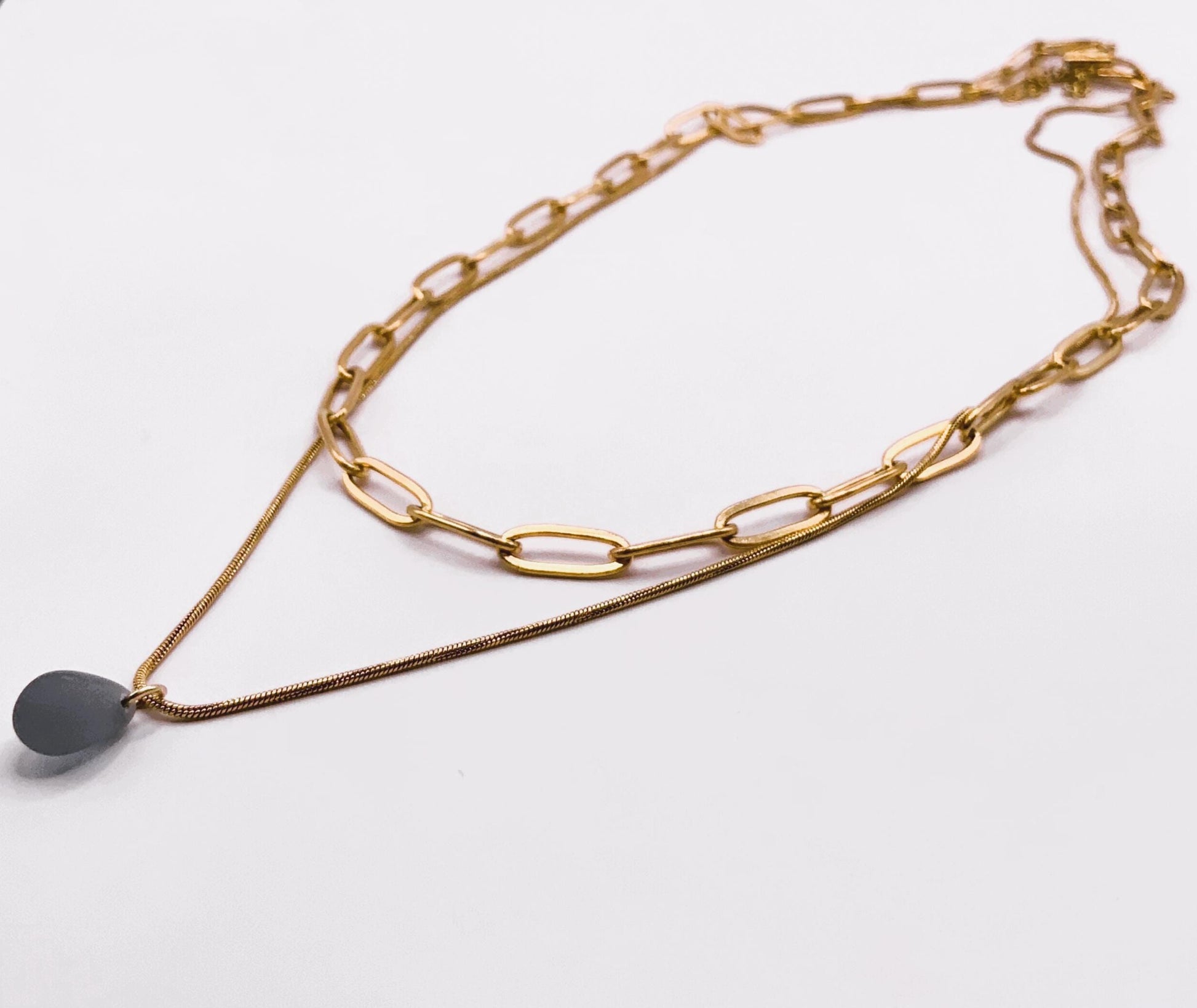 Double-layer gold cable chain necklace with a frosted blue glass teardrop charm, handcrafted for women who embrace individuality.