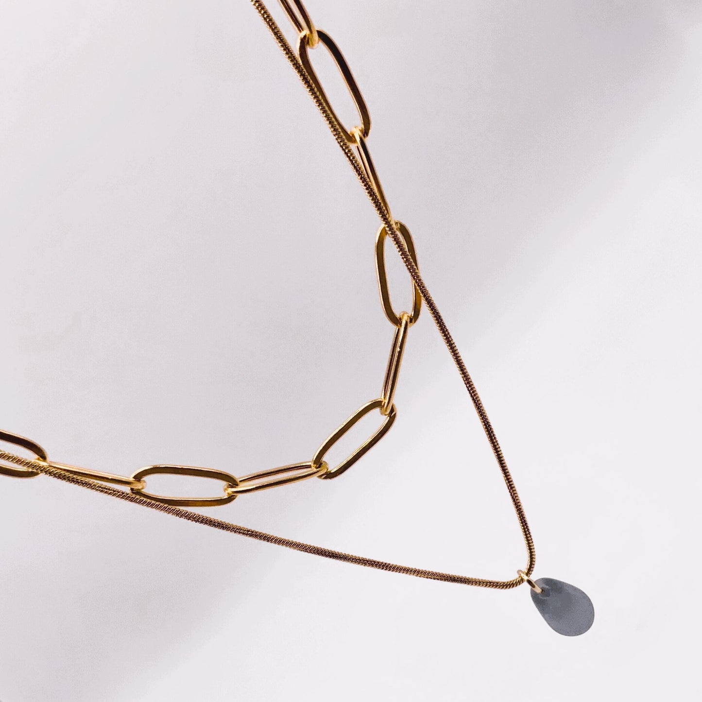 Chunky gold cable chain necklace with a frosted blue glass teardrop pendant, a bold yet minimalist design for everyday wear.
