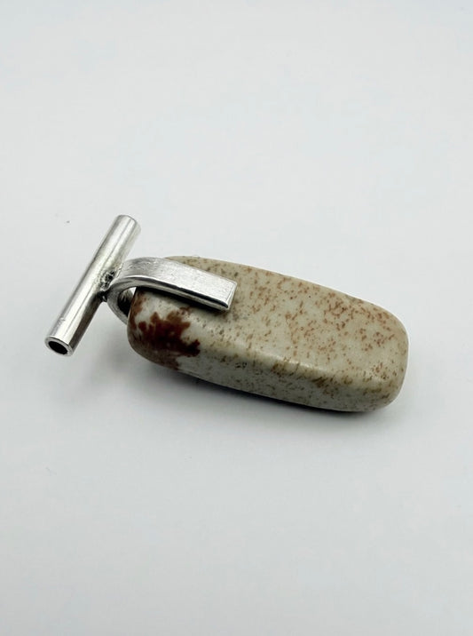 Close-up of the landscape jasper stone pendant with sterling silver T-bar detail on a light gray background
