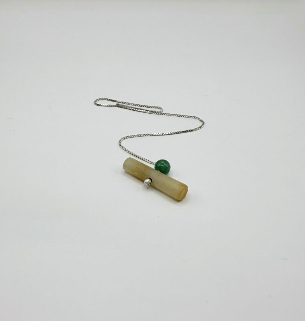 Single sterling silver threader earring with a yellow jadeite cylinder and green aventurine bead on a white background