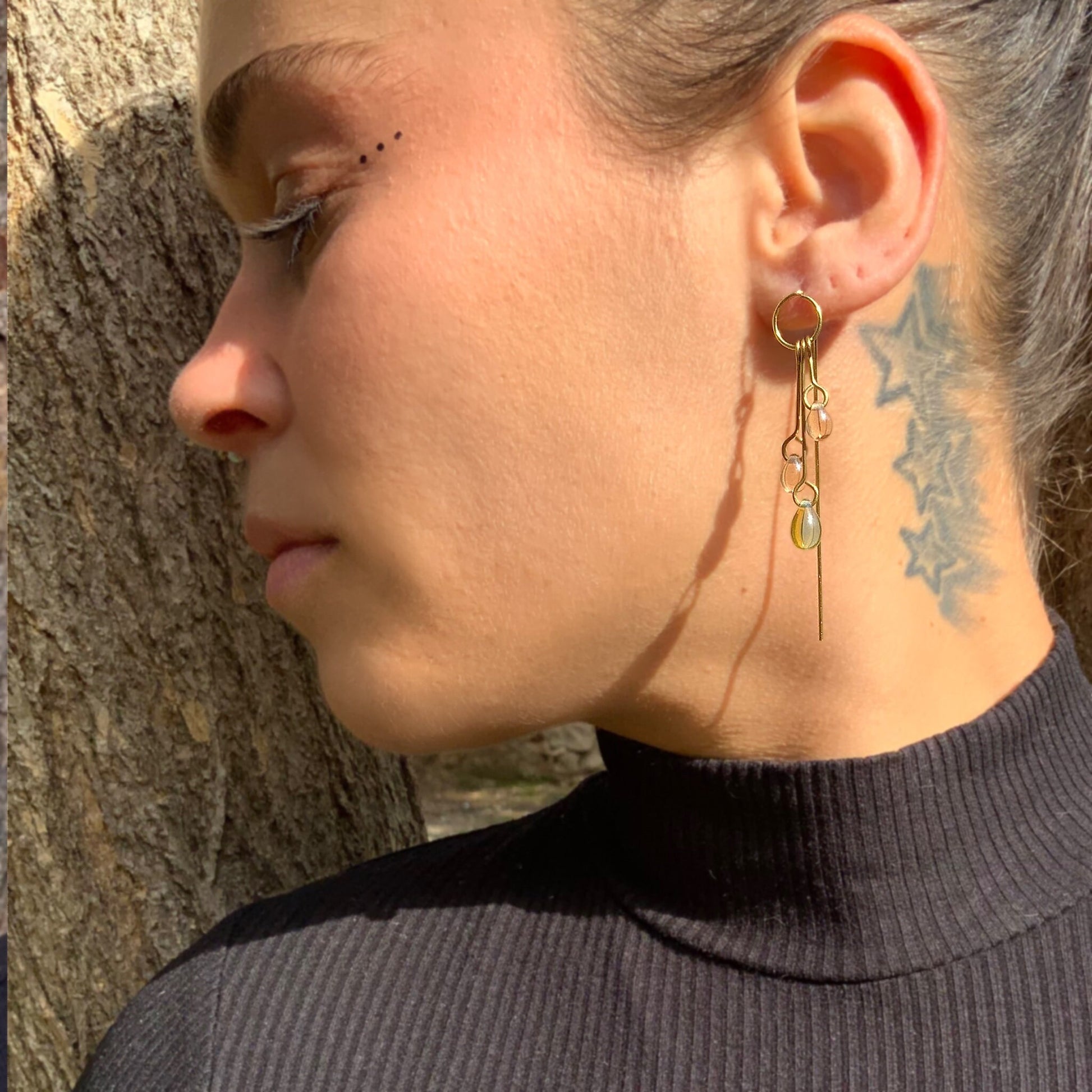 woman-wearing-layered-gold-threader-earrings-with-glass-teardrop-beads-outdoors-background-lifestyle-photo-jewelry-by-meow-iris-collection-phaedra-earrings